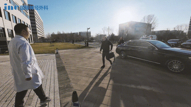 福教授乘车来到北京天坛医院。下车后，他上前与等候在此的天坛医院国际部的医生们微笑握手问好，而后一同走进医院，开始他忙碌而紧张的一日。