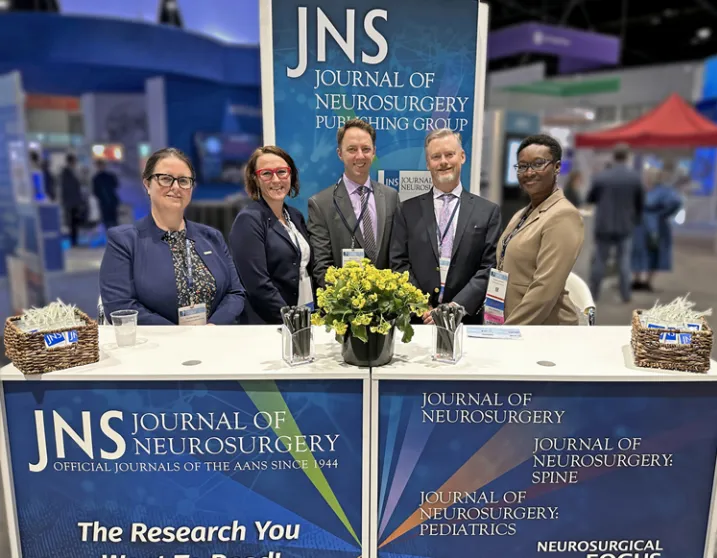 2024年AANS年度科学会议展位的照片。JNSPG工作人员，从左至：Gillian Shasby、Samantha Geouge、Ben Jipson、James Dell和Rhonda Jeffers。