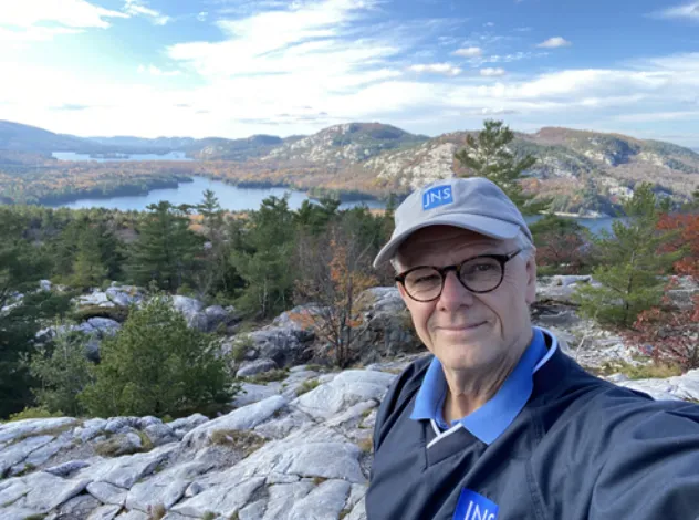 作者在安大略省基拉尼Cloche Silhouette Trail的山顶，自豪地展示已向所有编辑委员会成员展示的JNSPG服装。